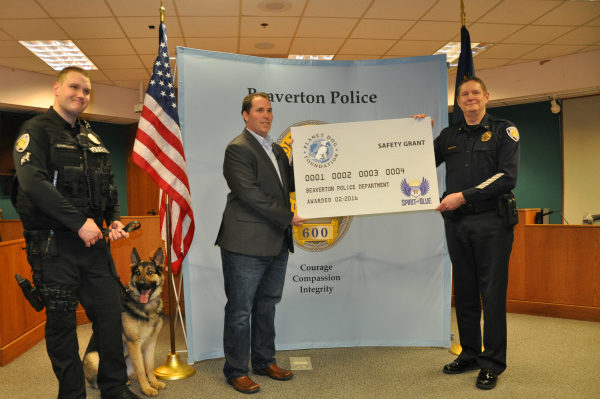 Image Caption – Spirit of Blue presented a $2,500 grant to the Beaverton Police Department for the acquisition of a new K9 working dog, sponsored by the Planet Dog Foundation. The grant was presented by Ryan T. Smith of Spirit of Blue (center) and was received by (left to right) Officer Matt Barrington, K9 Atlas and Chief Geoff Spalding.