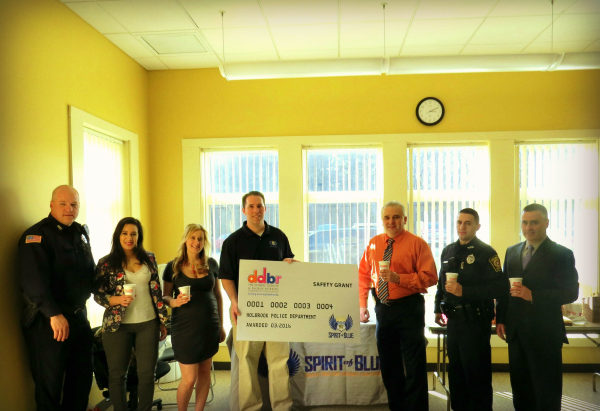Image Caption – Chief William Smith (center right) accepted the Spirit of Blue safety grant on behalf of the officers of the Holbrook Police Department, along with Town Administrator Timothy Gordon (far right). Presenting the grant was Spirit of Blue Executive Director, Ryan T. Smith (center left) and local Dunkin’ Donuts franchise owners Monica MacFarlane and Nicole Loredo.
